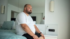 Pessoa com sobrepeso ou obesidade, com um diagrama de coração e vasos sanguíneos, simbolizando risco cardiovascular.